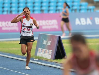 Reaksi pelari putri Indonesia, Odekta Elvina Naibaho menjelang garis finis pada nomor lari 10.000 meter SEA Games 2023 di Stadion Morodok Techo National Stadium, Phnom Penh, Kamboja, Jumat (12/5/2023). Odekta meraih medali perunggu dengan catatan waktu 35 menit 31,03 detik sementara medali emas dan perak direbut dua atlet Vietnam, Thi Oanh Nguyen (35 menit 11,53 detik) dan Thi Hong Le Pham (35 menit 21,09 detik). (Bola.com/Abdul Aziz)