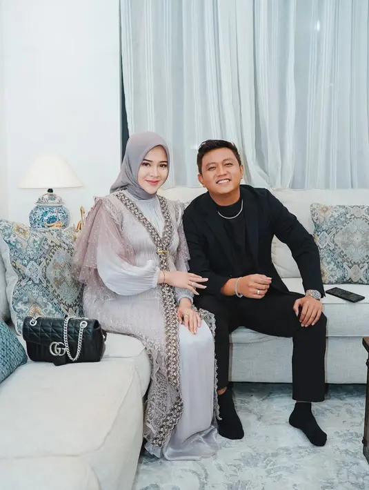 Penampilan yang cukup kontras ketika Bella Bonita tampil cantik elegan mengenakan outfit santun berhijab. Gamis panjang dengan outernya yang manis, dipadukan hijab polos yang semuanya berwarna abu-abu. [Foto: Instagram/bellabonita_r.a]