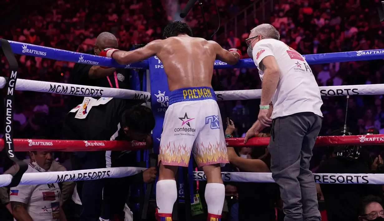 Pelatih Freddie Roach berbicara kepada Manny Pacquiao, dari Filipina, di antara ronde melawan Yordenis Ugas, dari Kuba, dalam pertandingan tinju kejuaraan kelas welter Sabtu, 21 Agustus 2021, di Las Vegas. (AP Photo/John Locher)