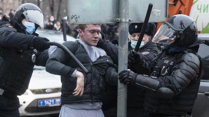 Petugas polisi menahan seorang pria selama protes terhadap pemenjaraan pemimpin oposisi Alexei Navalny di Moskow, Rusia, Sabtu (23/1/2021). Puluhan ribu pendukung melakukan unjuk rasa di seluruh Rusia setelah Navalny ditahan di bandara Moskow. (AP Photo/Pavel Golovkin)
