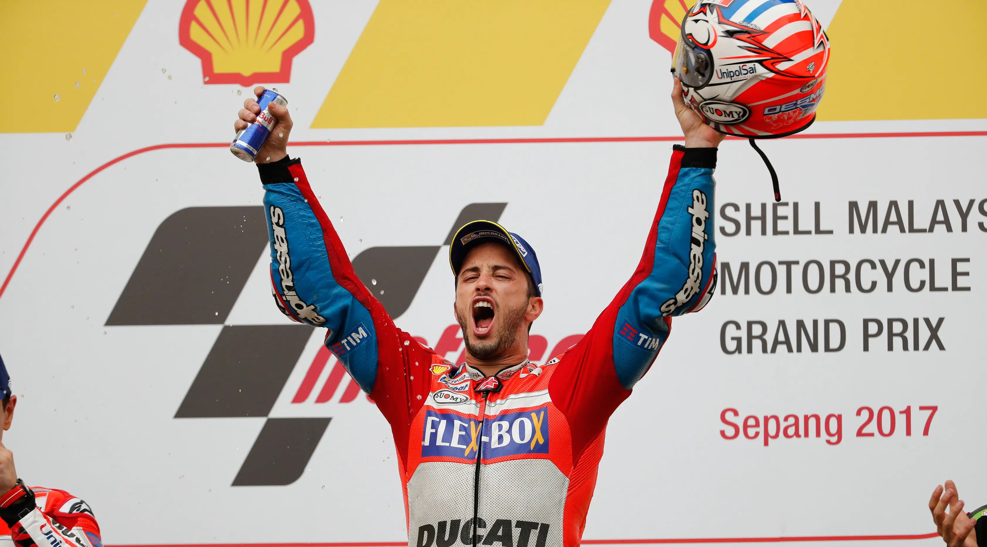 Pembalap Ducati Team, Andrea Dovizioso selebrasi di atas podium setelah berhasil memenangkan MotoGP Malaysia di sirkuit Sepang, Minggu (29/10). Dovizioso menyelesaikan balapan dengan catatan waktu 44 menit 51.497 detik. (AP/Vincent Thian)