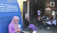 Sejumlah warga menunggu proses administrasi perubahan nama jalan pada KTP elektronik di Halaman Masjid Al Hikmah Hidayah, Cipayung, Jakarta Timur, Rabu (29/6/2022). Pemprov DKI Jakarta menggelar pelayanan jemput bola di enam wilayah terkait perubahan data administrasi kependudukan imbas pergantian 22 nama jalan menggunakan nama tokoh Betawi. (Liputan6.com/Herman Zakharia)