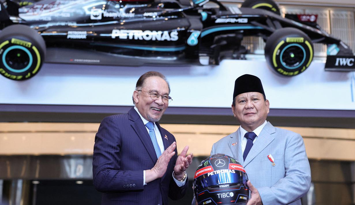 Presiden Republik Indonesia, Prabowo Subianto (kanan) menerima helm Mercedes AMG Petronas F1 Team sebagai kenang-kenangan dari Perdana Menteri Malaysia, Anwar Ibrahim dalam sebuah pertemuan di Kuala Lumpur pada tanggal 27 Januari 2025. (HASNOOR HUSSAIN/POOL/AFP)