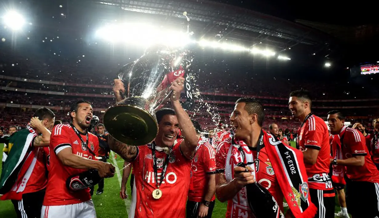 Bersama pemain Benfica lainnya, Maxi Pereira (bek Benfica) mengangkat trofi liga Portugal di Estadio Da Luz, Lisbon, Senin (21/4/2014) (AFP PHOTO/FRANCISCO LEONG)