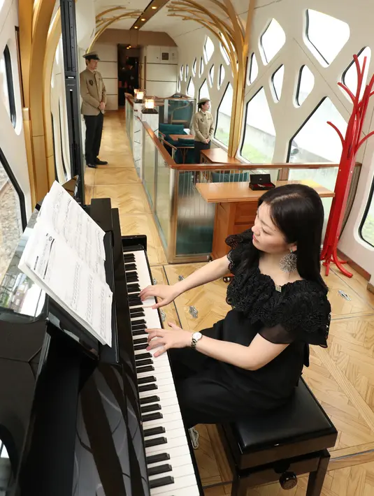 Seorang wanita memainkan piano di lounge kereta api mewah "Train Suite Shiki-Shima" di Tokyo, Jepang, 16 Maret 2017. Pelanggan bisa memilih jenis perjalanan yang diinginkan, dengan paket dan rute yang berbeda-beda di setiap musimnya. (str/JIJI PRESS/AFP)
