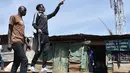 Artis hip hop Kenya Henry Ohanga berjalan dengan temannya di sepanjang jalur kereta api saat di Kibera di Nairobi, Kenya (16/1). Octopizzo 29 tahun saat ini menjadi salah satu bintang hip-hop paling terkenal di Afrika Timur. (AFP Photo/Tony Karumba)