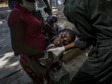 Seorang pemuda yang menderita gejala kolera ditolong setibanya di sebuah klinik yang dikelola oleh Doctors Without Borders di Port-au-Prince, Haiti, Kamis, 27 Oktober 2022. Untuk pertama kalinya dalam tiga tahun, orang-orang di Haiti telah sekarat karena kolera, meningkatkan kekhawatiran tentang skenario yang berpotensi menyebar cepat dan menghidupkan kembali ingatan tentang epidemi yang menewaskan hampir 10.000 orang satu dekade lalu. (AP/Ramon Espinosa)