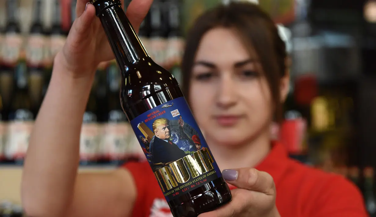 Karyawan menunjukkan botol bir bergambar Presiden AS Donald Trump di perusahaan bir Pravada di Lviv, Ukraina, 20 Mei 2017. Perusahaan itu menciptakan bir yang dijuluki sebagai 'Trump. The President of the Divided States of America'. (Yuri DYACHYSHYN/AFP)