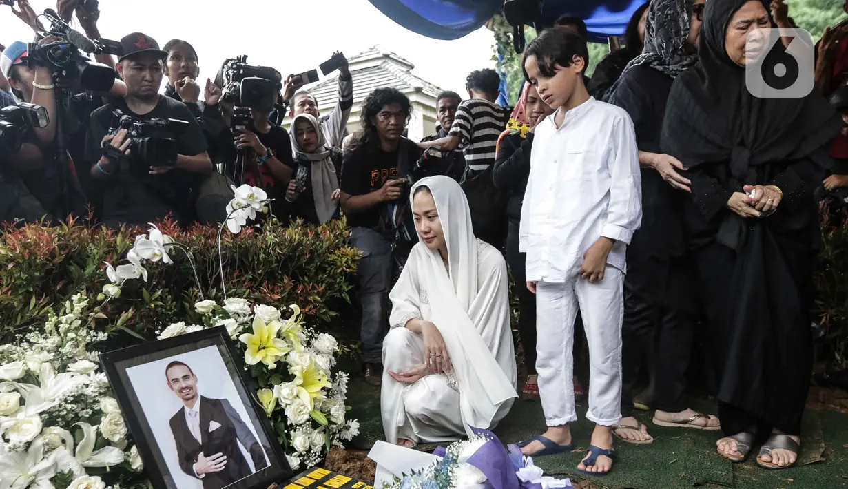 Bunga Citra Lestari atau BCL bersama anaknya Noah Sinclair memandangi foto Ashraf Sinclair saat pemakaman di San Diego Hills, Karawang, Jawa Barat, Selasa (18/2/2020). Ashraf Sinclair mengembuskan napas terakhir pukul 04.51 WIB pagi tadi. (Liputan6.com/Faizal Fanani)