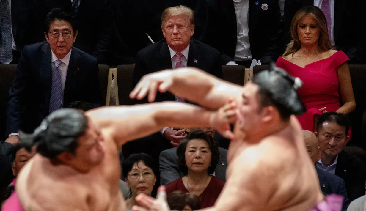 Presiden AS Donald Trump (tengah) didampingi PM Jepang Shinzo Abe (kiri) menyaksikan Tokyo Grand Sumo Tournament di Stadion Ryogoku Kokugikan, Tokyo, Jepang, Minggu (26/5/2019). Trump merupakan Presiden AS pertama yang menonton sumo di Jepang. (AP Photo/Evan Vucci)