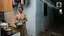 Seorang ibu memasak di depan rumah di kawasan Kampung Akuarium, Jakarta, Selasa (17/2/2021). Badan Pusat Statistik (BPS) mengungkapkan jumlah penduduk miskin Indonesia pada September 2020 mencapai 27,55 juta orang, meningkat 2,76 juta dibandingkan posisi September 2019. (Liputan6.com/Faizal Fanani)