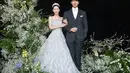 Foto kedua memperlihatkan Lee Da In merangkul tangan Lee Seung Gi mengenakan strapless dress dan tiara. [Foto: IG/byhumanmade].