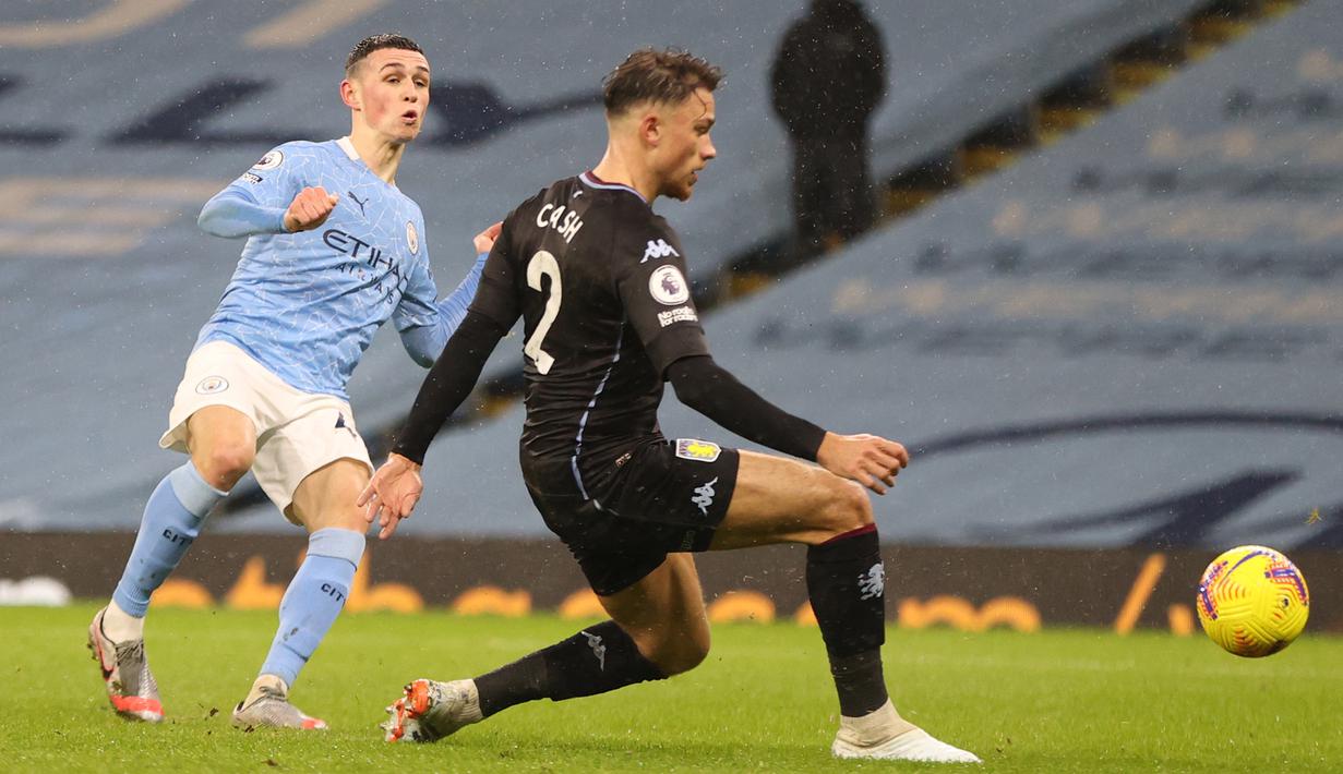 Gelandang Manchester City, Phil Foden, melepaskan tendangan saat menghadapi Aston Villa pada laga lanjutan Liga Inggris di Etihad Stadium, Kamis (21/1/2021) dini hari WIB. Manchester City menang 2-0 atas Aston Villa. (AFP/Clive Brunskill/pool)