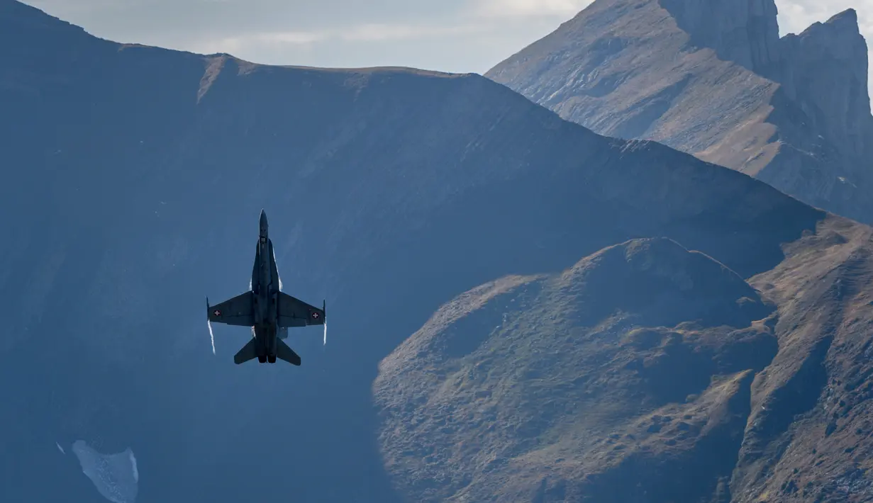 Jet tempur F/A-18 Hornet melakukan atraksi di atas penonton selama demonstrasi penerbangan Angkatan Udara Swiss di Axalp, 10 Oktober 2018. (Photo by Fabrice COFFRINI / AFP)