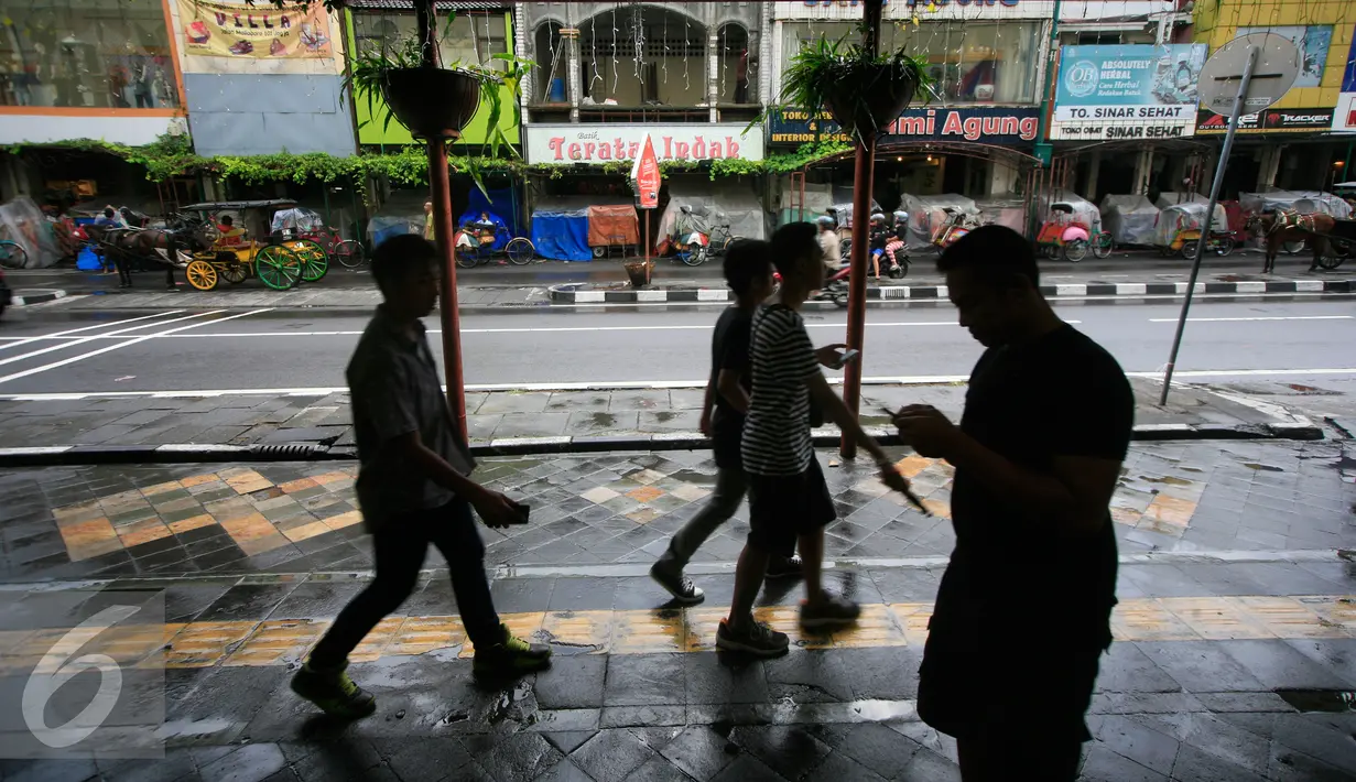 Pejalan kaki melintas di kawasan pedestrian Malioboro,Yogyakarta, Jumat (8/4). Sejak bebas dari parkir kendaraan bermotor, kawasan tersebut tampak lebih bersih dan rapi. (Liputan6.com/Boy Harjanto)