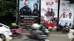 Kendaraan melintas dekat alat peraga kampaye Pilkada DKI 2017 yang berisi nama Cagub-Cawagub di Tugu Tani, Jakarta, Minggu  (20/11). KPUD DKI Jakarta mulai memasang baliho berukuran 4 m x 6 m di sejumlah titik di ibu kota. (Liptan6.com/Faizal Fanani)