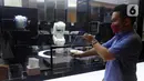 Pelanggan mengambil pesanan minuman buatan robot barista di Family Mart, Grand Indonesia East Mall, Jakarta, Senin (10/1/2022). FamilyMart Indonesia meluncurkan pengoperasian robot barista yang mampu membuat minuman untuk pelanggan dalam waktu satu hingga dua menit. (merdeka.com/Arie Basuki)