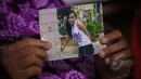 Narsiah, ibu kandung Wanipah menunjukan foto anaknya, di sekretariat SPILN, Jakarta, Minggu (17/5). Narsiah menyampaikan permohonan bantuan kepada Presiden Jokowi terkait ancaman hukuman mati TKI Wanipah. (Liputan6.com/Faizal Fanani)