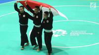 Nunu Nugraha, Asep Yuldan Sani, dan Anggi Faisal Mubarok mengibarkan bendera Merah Putih usai tampil dalam babak final pencak silat beregu putra Asian Games 2018 di TMII, Jakarta, Senin (27/8). (Merdeka.com/Arie Basuki)