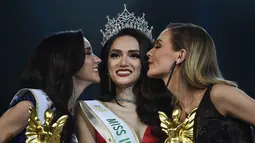 Nguyen Huong Giang dari Vietnam mendapatkan ciuman dari pesaingnya yang meraih juara dua, dan tiga dalam final kontes kecantikan transgender Miss International Queen 2018 di Pattaya, Thailand (9/3). (AFP Photo/Lillian Suwanrumpha)