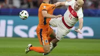 Striker Turki Baris Yilmaz terjengkal saat mendapatkan hadangan dari bek Belanda Stevan de Vrij pada laga perempat final Euro 2024 di Olympia Stadion (AP)
