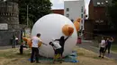 Aktivis mengembangkan balon berbentuk bayi Presiden AS Donald Trump di Bingfield Park, London, 10 Juli 2018. Balon bayi atau disebut Trump Baby itu dirancang sebagai pernyataan protes untuk Trump yang akan mengunjungi Inggris.  (AP /Matt Dunham)