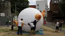Aktivis mengembangkan balon berbentuk bayi Presiden AS Donald Trump di Bingfield Park, London, 10 Juli 2018. Balon bayi atau disebut Trump Baby itu dirancang sebagai pernyataan protes untuk Trump yang akan mengunjungi Inggris.  (AP /Matt Dunham)