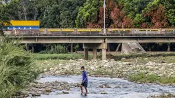 Seorang Venezuela yang mengenakan masker untuk mencegah penyebaran virus corona mencoba masuk ke Kolombia melalui "trocha" - jalur ilegal di perbatasan antara Kolombia dan Venezuel, dekat jembatan internasional Simon Bolivar, di Cucuta, Kolombia (14/10/2020). (AFP/Schneyder Mendoza)