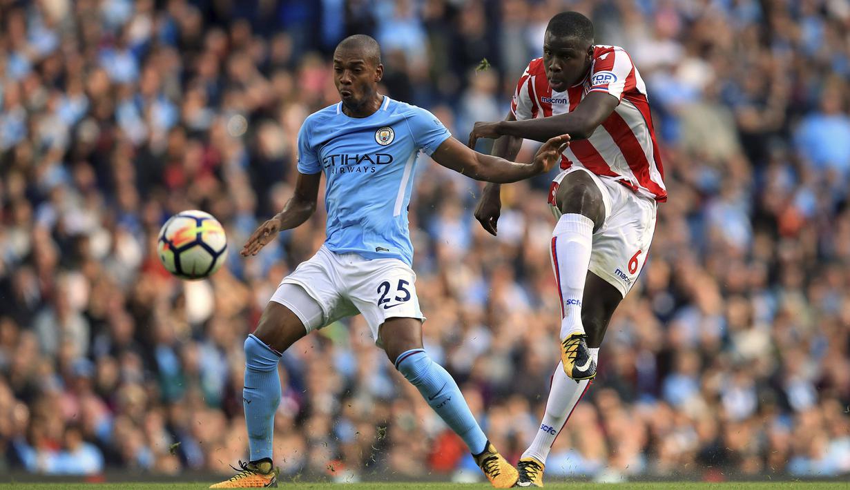 Aksi pemain Stoke City, Kurt Zouma (kanan) melepaskan tembakan saat diadang pemain Manchester City, Fernandinho pada lanjutan Premier League di Etihad Stadium, Manchester, (14/10/2017). City menang 7-2.  (Mike Egerton/PA via AP)