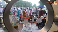 Jamaah yang tidak mendapatkan tempat di dalam masjid terpaksa menggelar koran sebagai alas untuk menunaikan salat (Liputan6.com/ Herman Zakharia).
