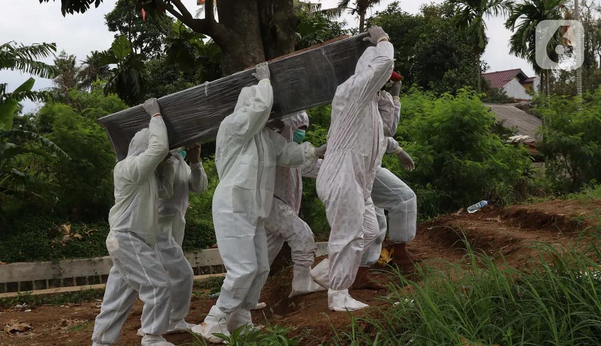 Petugas membawa peti jenazah yang akan dimakamkan dengan protokol COVID-19 di area khusus TPU Srengseng Sawah, Jakarta, Kamis (14/1/2021). TPU Srengseng Sawah mulai menerima pemakaman jenazah dengan protokol COVID-19 sejak Selasa (12/1) lalu. (Liputan6.com/Helmi Fithriansyah)