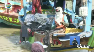Warga Karawang bersihkan minyak mentah Pertamina yang tercecer di pesisir pantai menggunakan perahu.