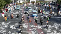 Lembaran koran bekas tak bertuan berserakan menghiasi jalan raya di Jatinegara, Jakarta, Kamis (24/9/2015). Lembaran-lembaran koran tersebut menjadi tak bertuan usai digunakan sebagai alas untuk salat Idul Adha.(Liputan6.com/Yoppy Renato)