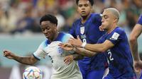 Penyerang Inggris, Raheem Sterling berebut bola dengan bek Amerika Serikat, Sergino Dest selama pertandingan grup B Piala Dunia 2022 Qatar di Stadion Al Bayt di Al Khor, Qatar, Sabtu (16/11/2022). Hasil ini bikin Inggris memimpin Grup B dengan empat angka. Sementara, Amerika Serikat di posisi ketiga dengan dua poin tertinggal satu angka dari Iran di posisi kedua. (AP Photo/Andre Penner)