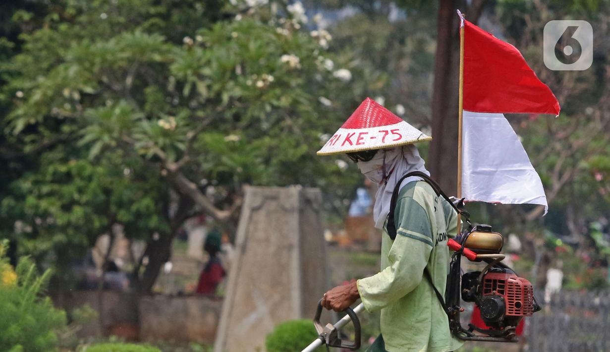 Petugas Pertamanan dan Kehutanan Kota Jakarta Pusat mengenakan atribut kemerdekaan saat memotong rumput di TPU Karet Bivak, Jakarta, Minggu (16/8/2020). Para petugas bekerja dengan mengenakan atribut kemerdekaan dalam rangka menyambut HUT ke-75 RI. (Liputan6.com/Herman Zakharia)