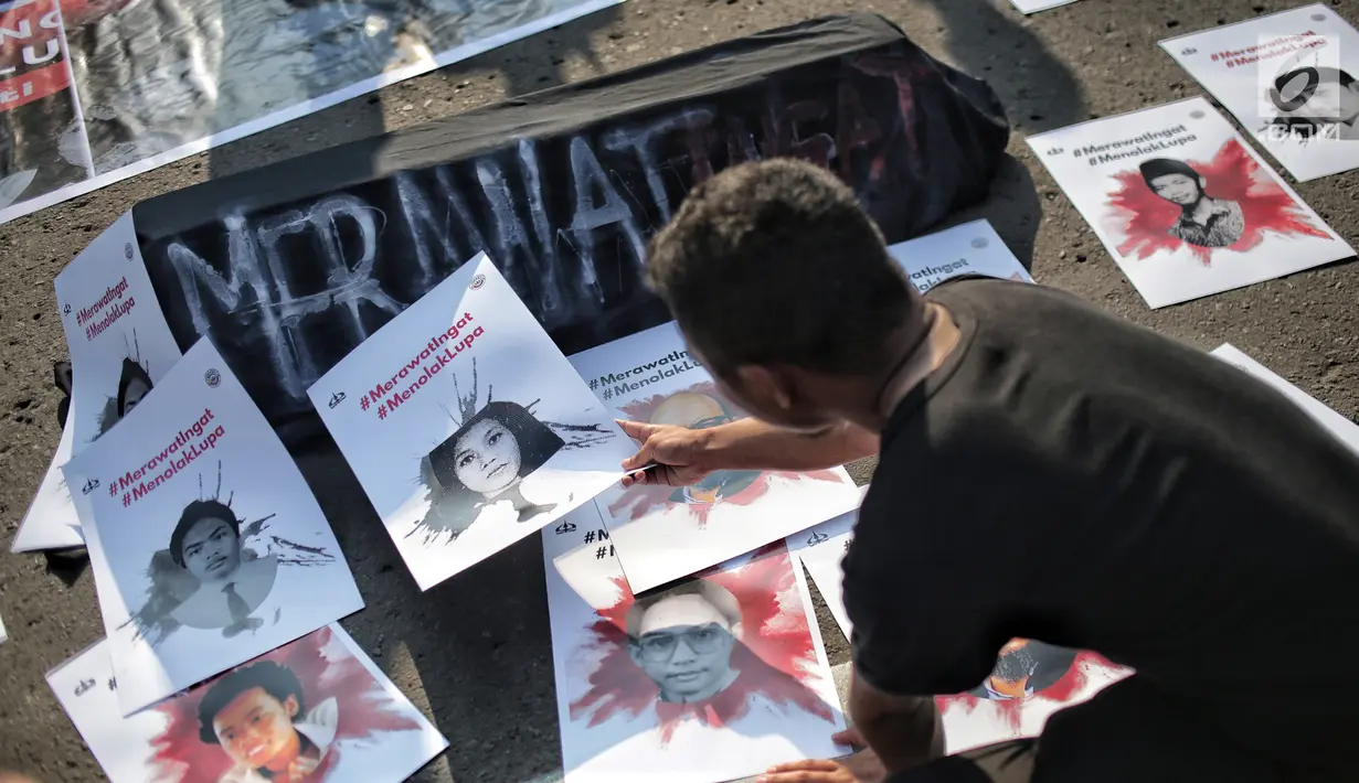 Mahasiswa meletakan poster selama aksi bertajuk #MerawatIngat #MenolakLupa saat car free day (CFD) di Bundaran HI, Jakarta, Minggu (5/5/2019). Aksi tersebut bertujuan untuk mengingatkan bahwa masih banyak kasus-kasus pelanggaran HAM berat yang belum terselesaikan. (Liputan6.com/Faizal Fanani)