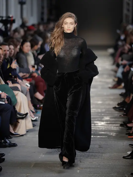 Gigi Hadid berjalan di atas catwalk mengenakan busana karya Max Mara selama Autumn / Winter 2017 di Milan Fashion Week, Italia (23/2). Gigi Hadid tampil cantik dan seksi dengan busana tipis berwarna hitam. (AP Photo / Luca Bruno)