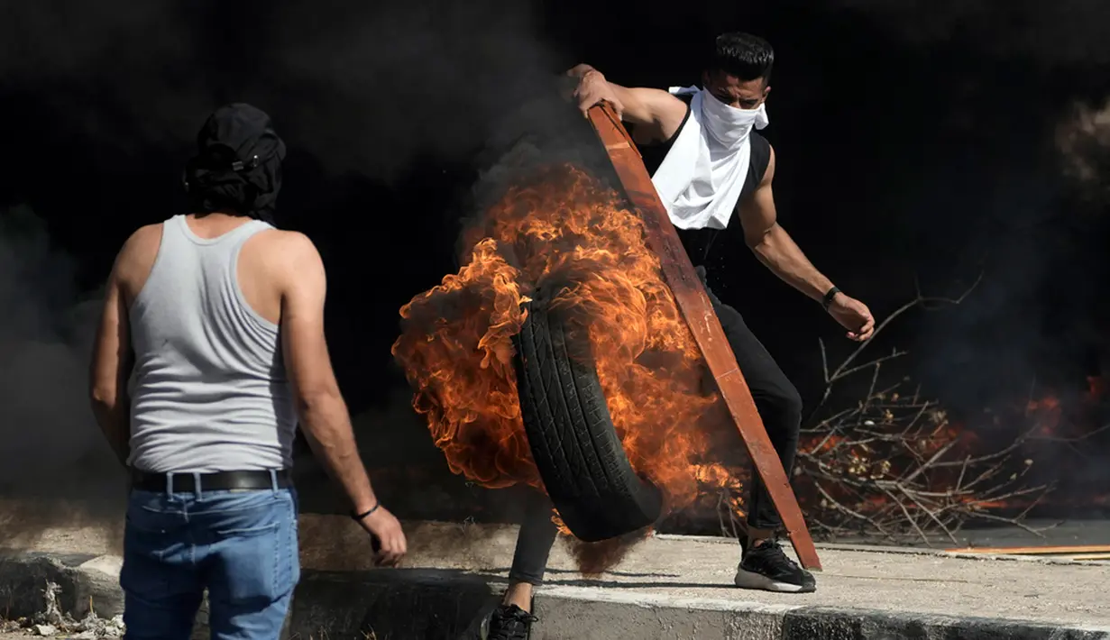 Demonstran Palestina bentrok dengan pasukan Israel menyusul demonstrasi mendukung Jalur Gaza di Kota Nablus, Tepi Barat, Jumat (13/10/2023). Pejuang Palestina mulai melakukan perlawanan di Tepi Barat. (AP Photo/Majdi Mohammed)