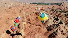 Sejumlah balon udara terbang di atas Taman Geologi Nasional Danxia di Zhangye, Provinsi Gansu, China barat laut, pada 26 Juli 2020. Sebuah festival balon udara internasional dibuka di Zhangye pada Minggu (26/7). Total 100 balon udara akan ditampilkan dalam festival tersebut. (Xinhua/Cheng Lin)