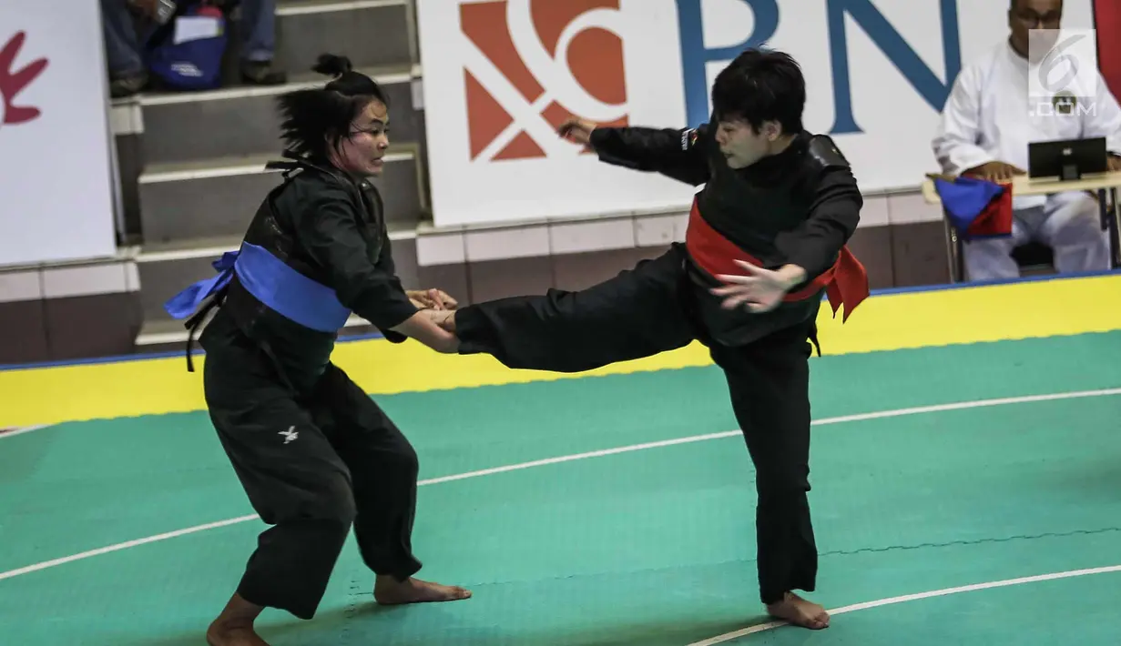 Pesilat Nirmalasari Oktaviani saat menendang pesilat Laos Olathai Sounthavong di semifinal 50-55 kg putri cabang Pencak Silat 18th Asian Games Invitation Tournament, Jakarta, Senin (12/2). Indonesia menang 5-0. (Liputan6.com/Faizal Fanani)