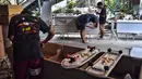 Foto pada 19 Maret 2021 menunjukkan pekerja dari toko peti mati Burapha sedang mengerjakan peti mati di dekat papan luncur yang terbuat dari kayu yang digunakan untuk peti mati, di Bangkok, Thailand. (Lillian SUWANRUMPHA/AFP)