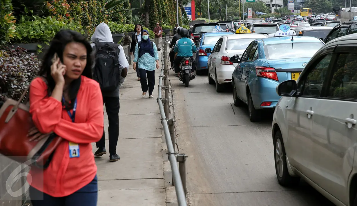 Sejumlah pejalan kaki melintas di trotoar kawasan Sudirman, Jakarta, Selasa (2/2/2016). Gubernur Ahok berencana akan membuat trotoar yang ramah kepada para penyandang disabilitas. (Liputan6.com/Faizal Fanani)
