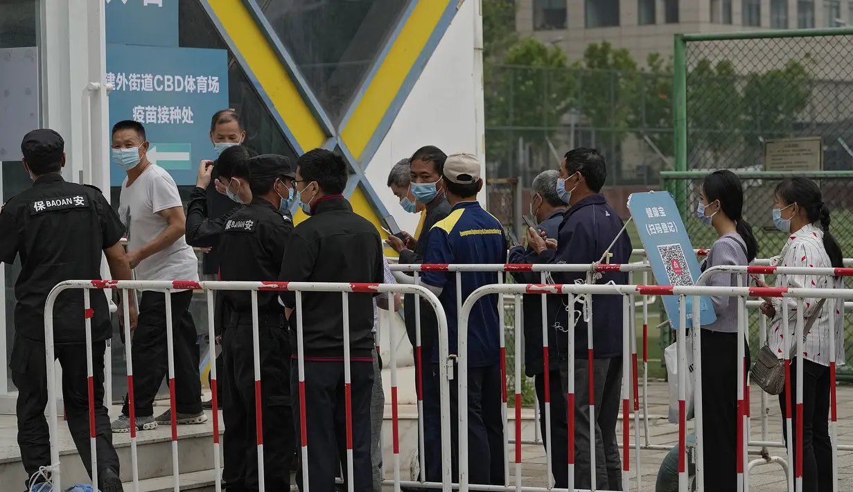 Warga mengenakan masker menunggu untuk memindai kode kesehatan mereka saat mereka mengantre untuk menerima vaksin Sinopharm COVID-19 di Central Business District di Beijing, Rabu (2/6/2021). (AP Photo/Andy Wong)