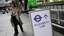 Seorang penumpang berjalan melewati tanda di Stasiun Canary Wharf Elizabeth Line yang baru dibuka di London Timur, Inggris, Senin (7/11/2022). Elizabeth Line baru saja melakukan layanan penuh gabungan untuk pertaman kalinya. (Daniel LEAL / AFP)