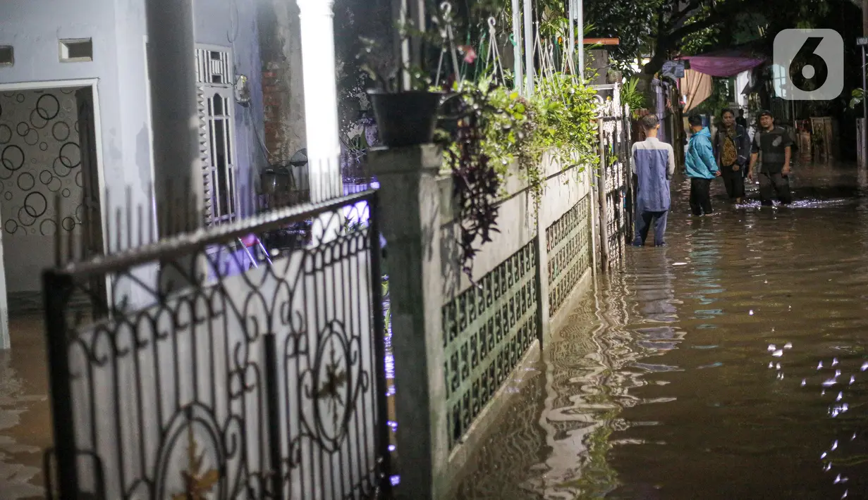 Warga berjalan menerjang banjir karena hujan di Jalan Shofa Marwah, Jakarta, Jumat (4/11/2022). Berdasarkan laporan Badan Penanggulangan Bencana Daerah (BPBD) DKI Jakarta yang diperbaharui pada pukul 18.00 WIB, terdapat 4 RT yang terendam banjir dengan ketinggian maksimal mencapai 50 Cm. (Liputan6.com/Faizal Fanani)