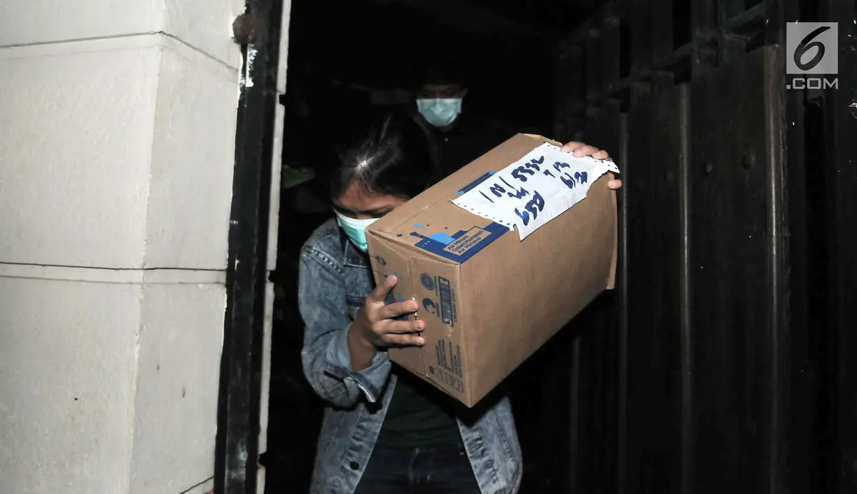 Penyidik KPK membawa kardus saat penggeledahan di rumah Dirut PLN Sofyan Basir di Bendungan Hilir, Jakarta, Minggu (15/7). Penggeledahan terkait pengembangan kasus dugaan suap PLTU Riau-1. (Merdeka.com/Iqbal S Nugroho)
