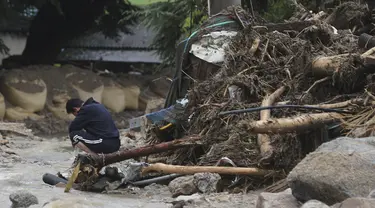 Seorang pria bereaksi di samping rumahnya yang runtuh setelah tanah longsor yang disebabkan oleh hujan lebat di Yecheon, Korea Selatan, Minggu, 16 Juli 2023.(Yun Kwan-shick/Yonhap via AP)