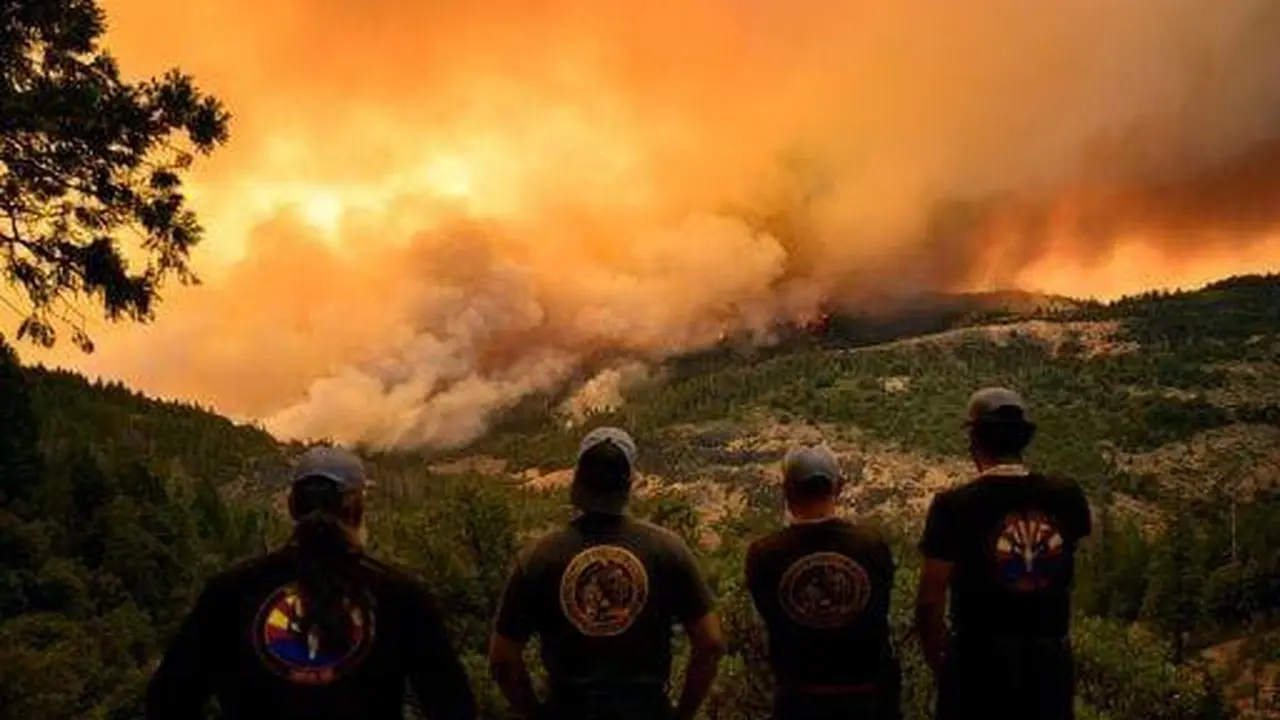 Petugas pemadam kebakaran menyaksikan api dan asap bergerak melalui lembah di area Forest Ranch di Butte County saat kebakaran terus membakar di dekat Chico, California. (AFP/Josh Edelson)