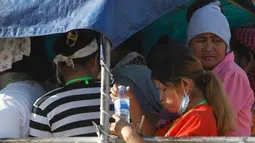 Para pekerja menaiki mobil bak terbuka sebagai transportasi harian mereka pulang ke rumah dari tempat kerja di sebuah pabrik di dekat desa Trapang Anchanh, di luar Phnom Penh, Kamboja (27/10). (AP Photo/Heng Sinith)