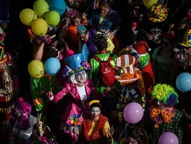 Orang-orang yang mengenakan pakaian badut ikut serta dalam parade badut tahunan di Sesimbra, Portugal pada Senin (4/3/2019). Perayaan ini dilakukan setiap tahun dan jatuh pada hari Senin. (PATRICIA DE MELO MOREIRA / AFP)